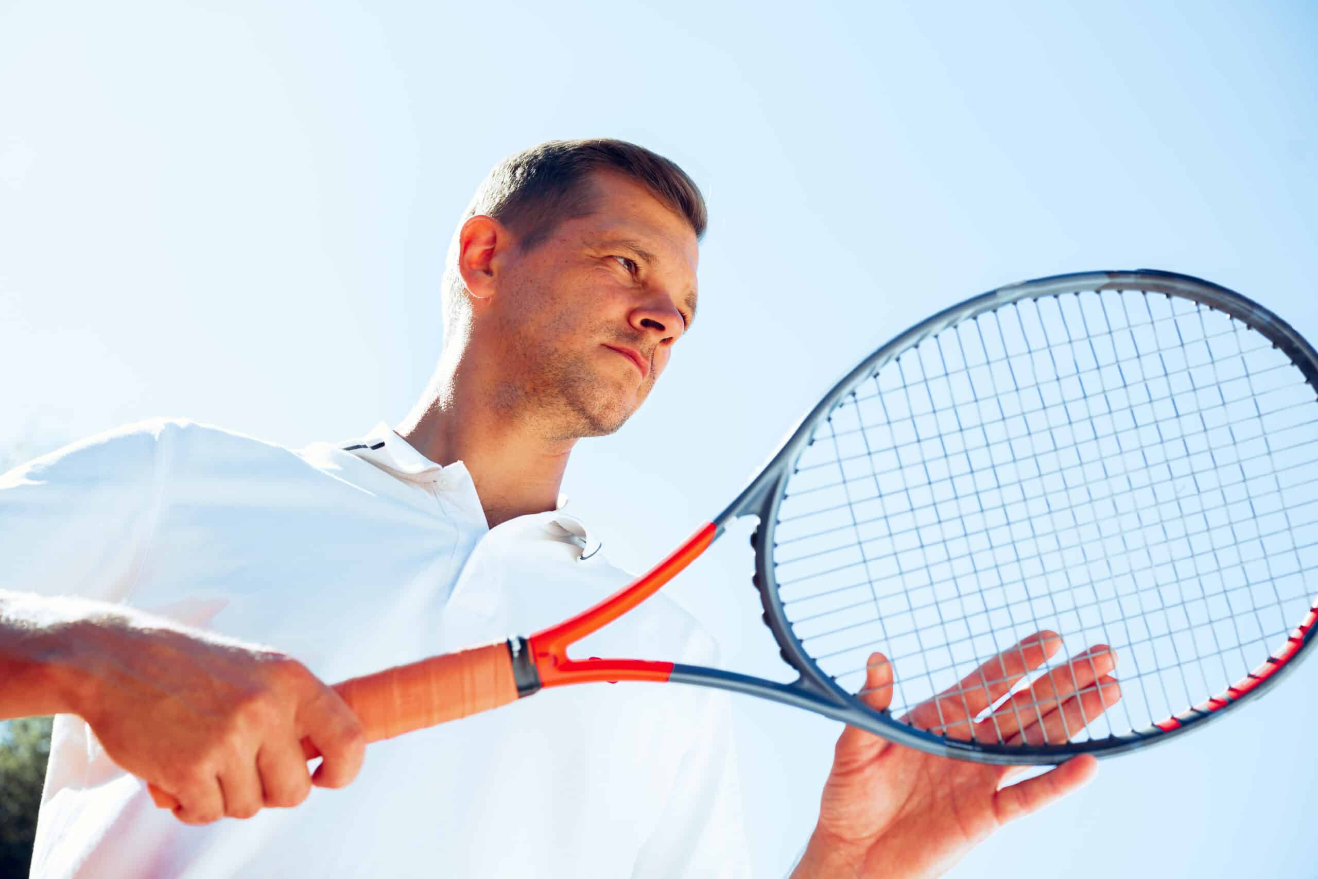young man tennis player checks his racket to start 2023 11 27 05 29 32 utc scaled